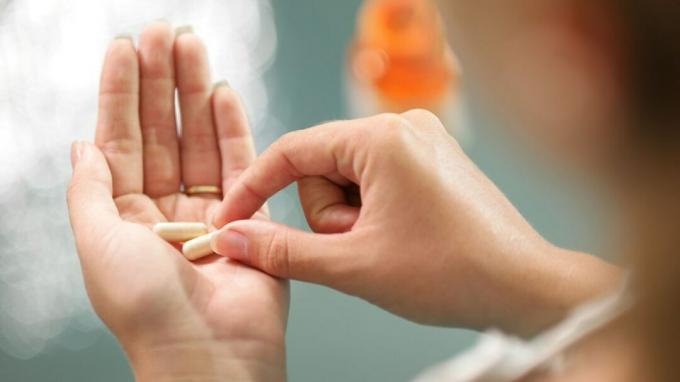 Mulher com TDAH segurando comprimidos de ritalina na palma da mão