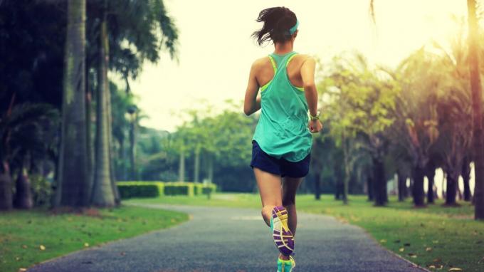 estilo de vida saudável jovem mulher asiática desportiva correndo no parque tropical